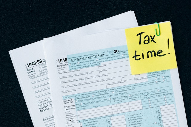 Tax return form with a yellow note that reads Tax Time attached to the upper right corner Tax return form with a yellow note that reads Tax Time attached to the upper right corner